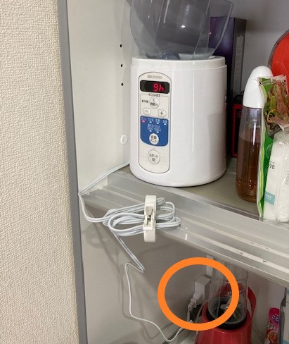 アイリスオーヤマIYM-013を食器棚に入れたまま電源コードを繋いだ様子の写真